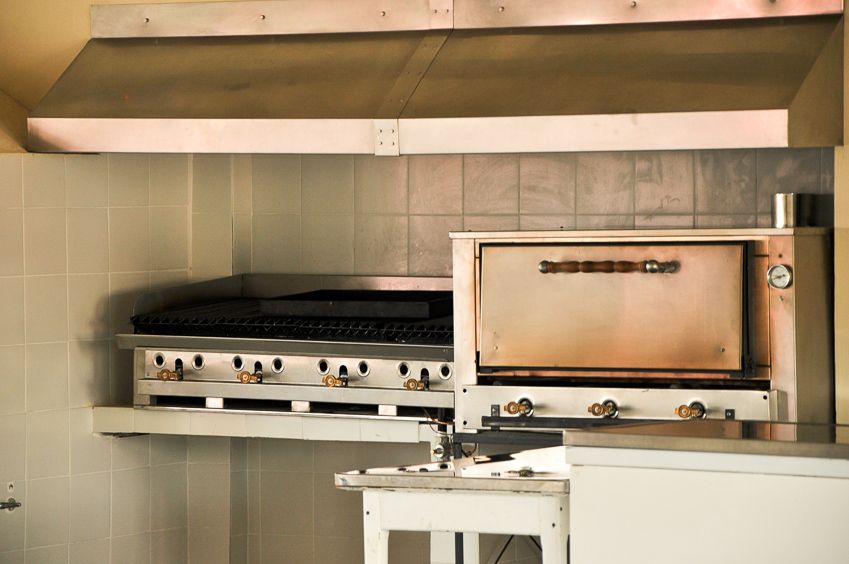 Cocina con plancha y horno pizzero de acero inoxidable