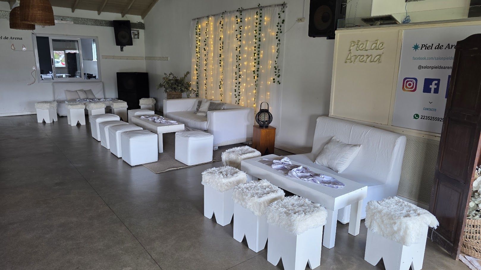 Livings blancos con puffs de piel, sillones y cortina de luces con enredadera