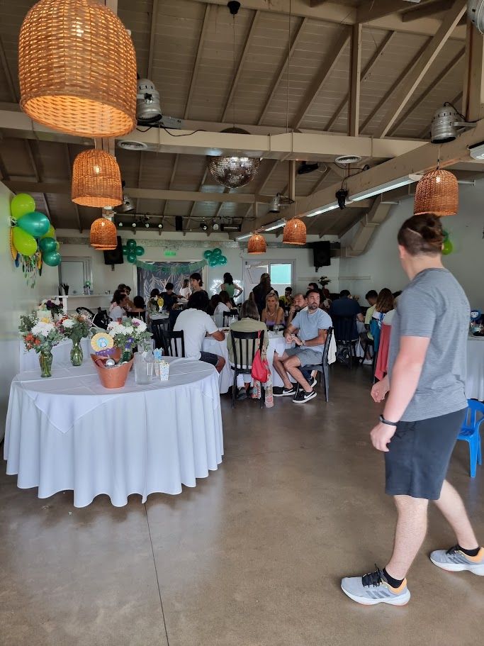 Festejo de día con mesa de recepción, flores y lámparas de mimbre